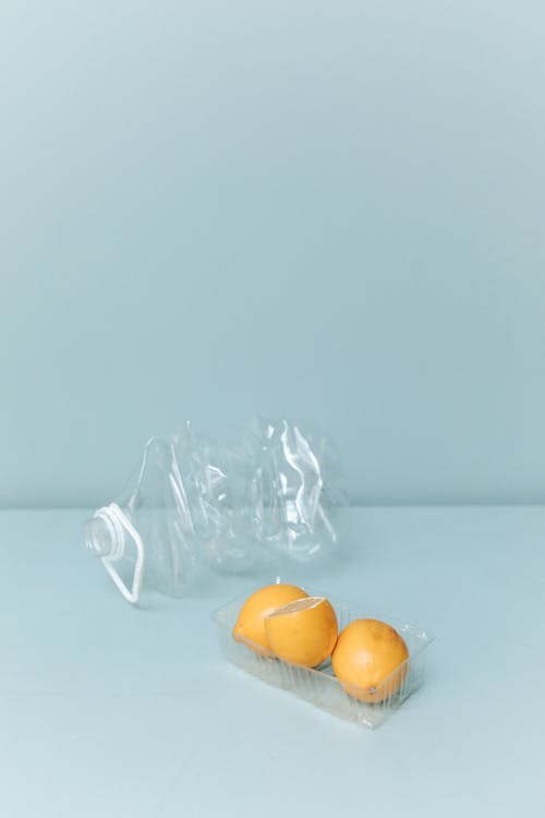 Crushed Plastic Bottle and Lemons in a Plastic Container 