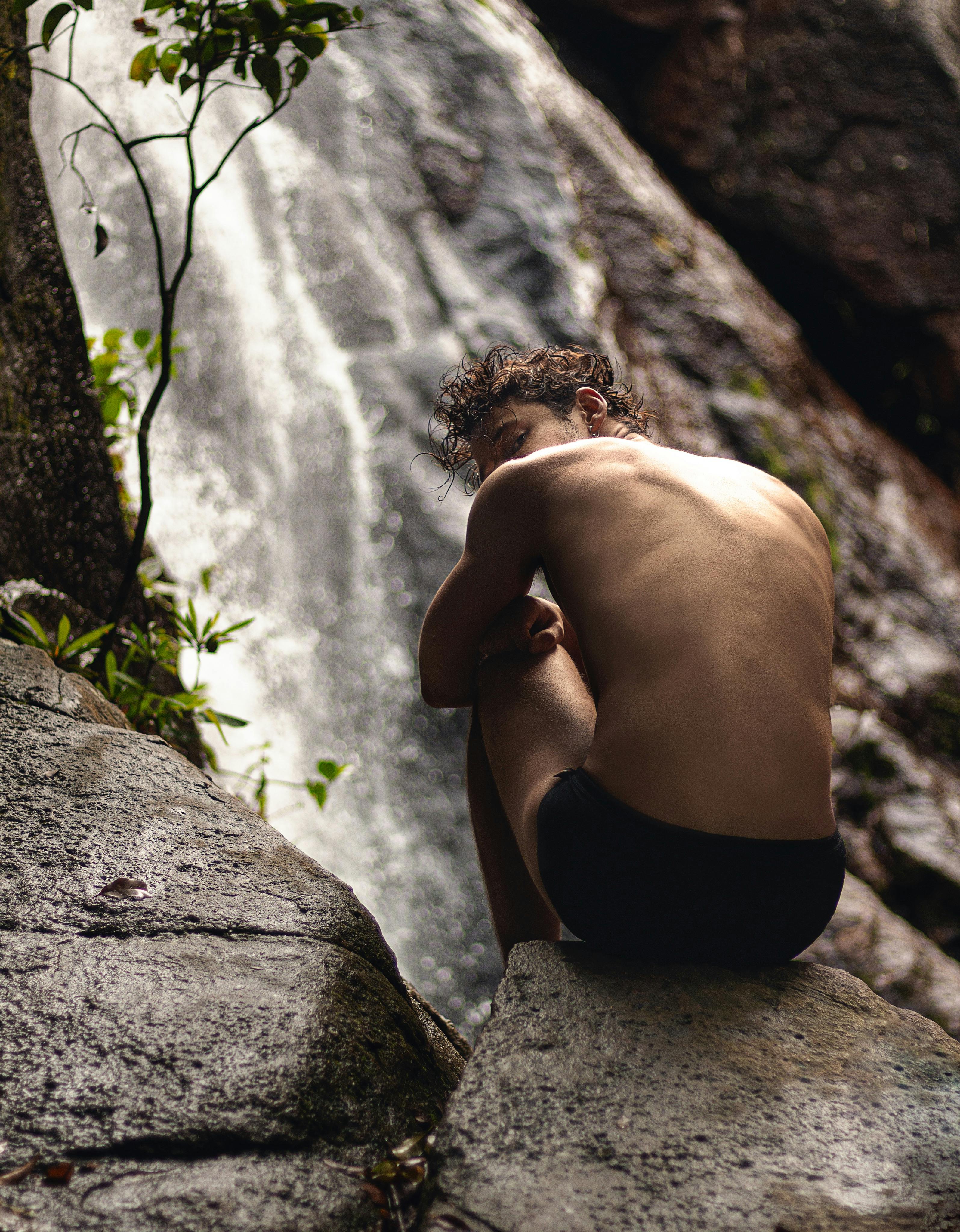 Naked Man Sitting on Rock at Waterfall · Free Stock Photo