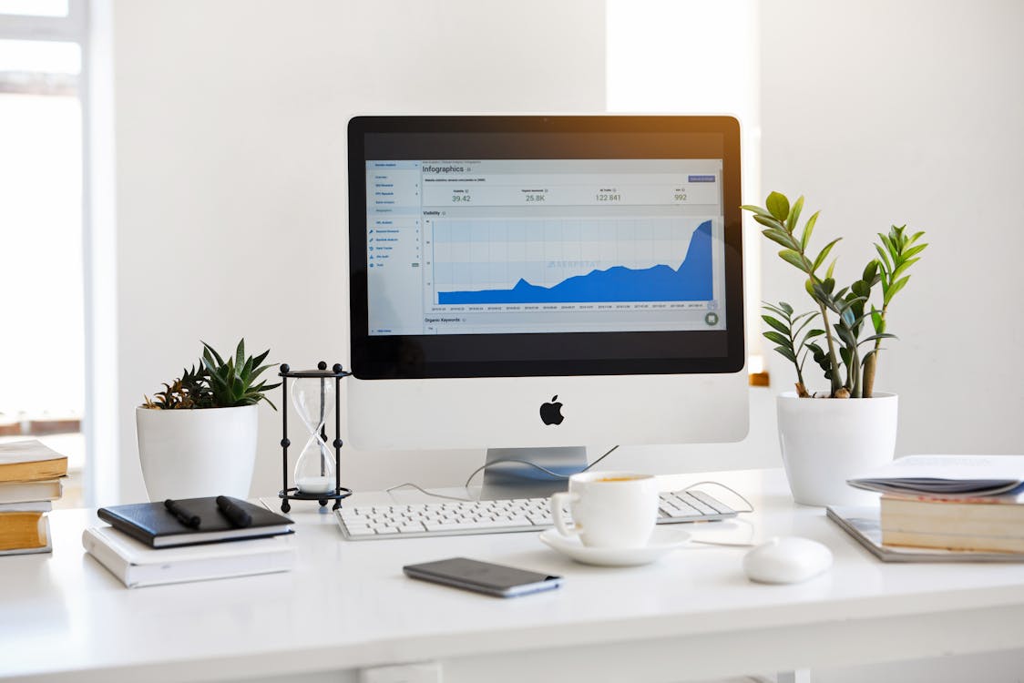 Kostenlos Silberner Imac Mit Liniendiagramm Auf Dem Schreibtisch Stock-Foto