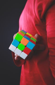 person holding a colorful 3x3 puzzle cube
