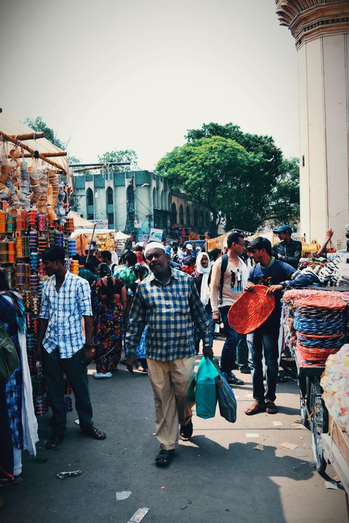 Free Bustling street market filled with people shopping and unique goods under a sunny sky. Stock Photo
