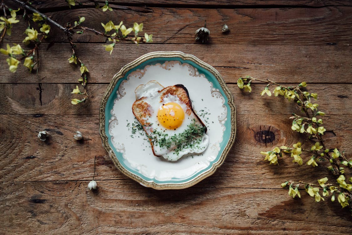 яйцо на бело голубой керамической тарелке · Бесплатные стоковые фото