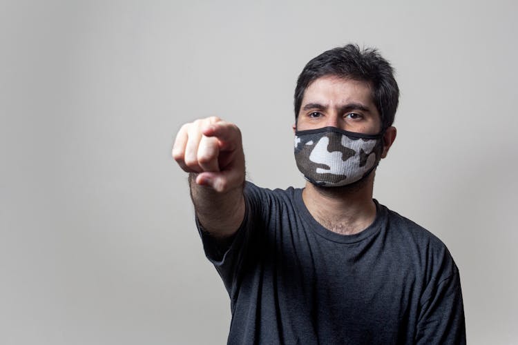 Man In Face Mask Pointing With Finger