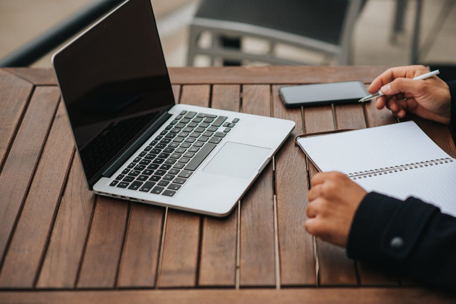person writing content laptop desk