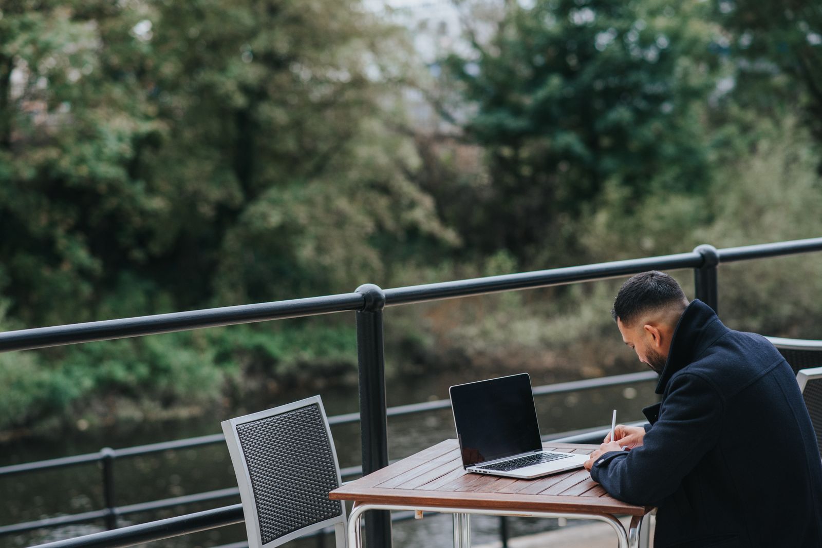 International professional taking notes near a laptop