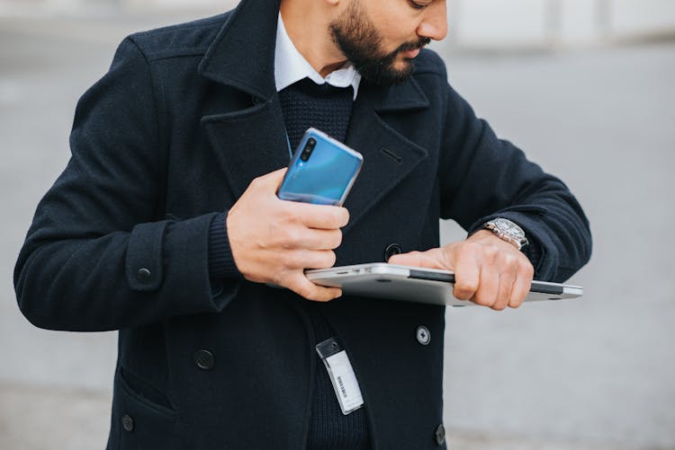 Crop Ethnic Manager With Multimedia Devices Watching Time On Wristwatch