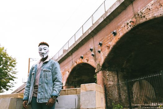 Faceless black man in mask of anonymous on street