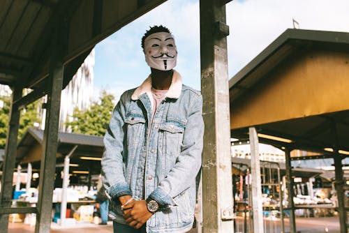 Free Man in Denim Jacket Wearing a Guy Fawkes Mask Stock Photo