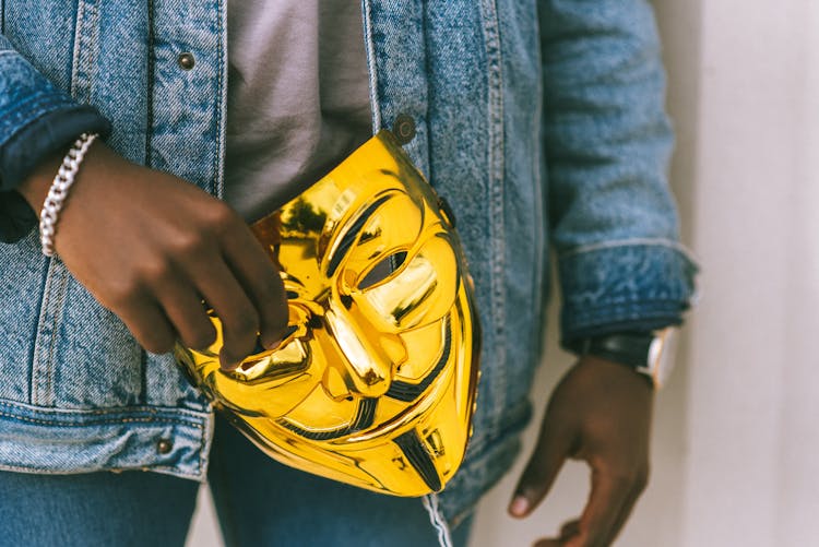 Person Holding A Gold Mask