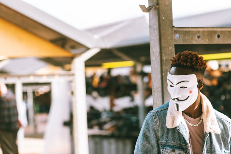 Ethnic Protester In Anonymous Mask On City Street