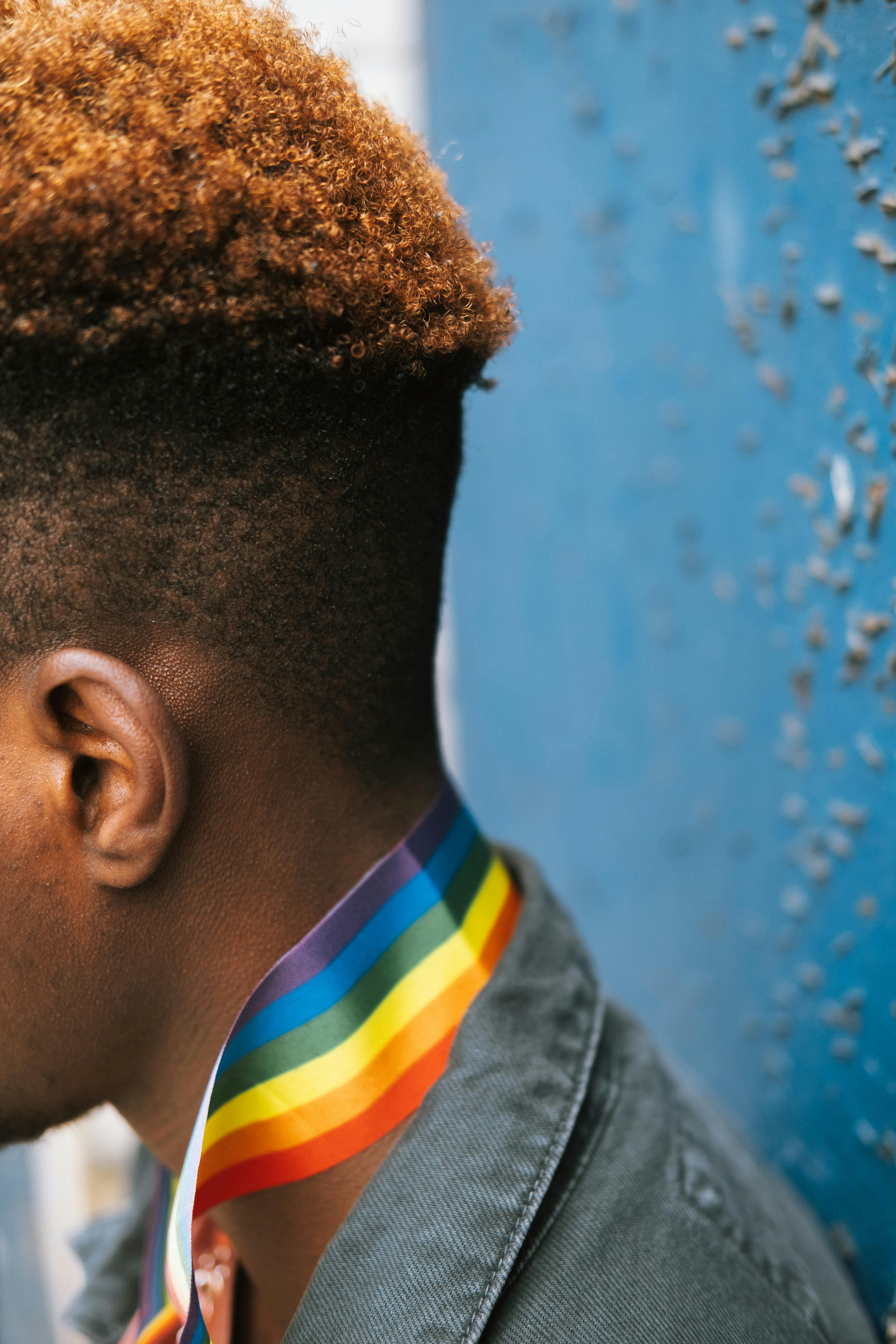 crop faceless black man wearing gay pride necklace