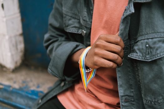 Crop unrecognizable black man wearing gay bracelet on street