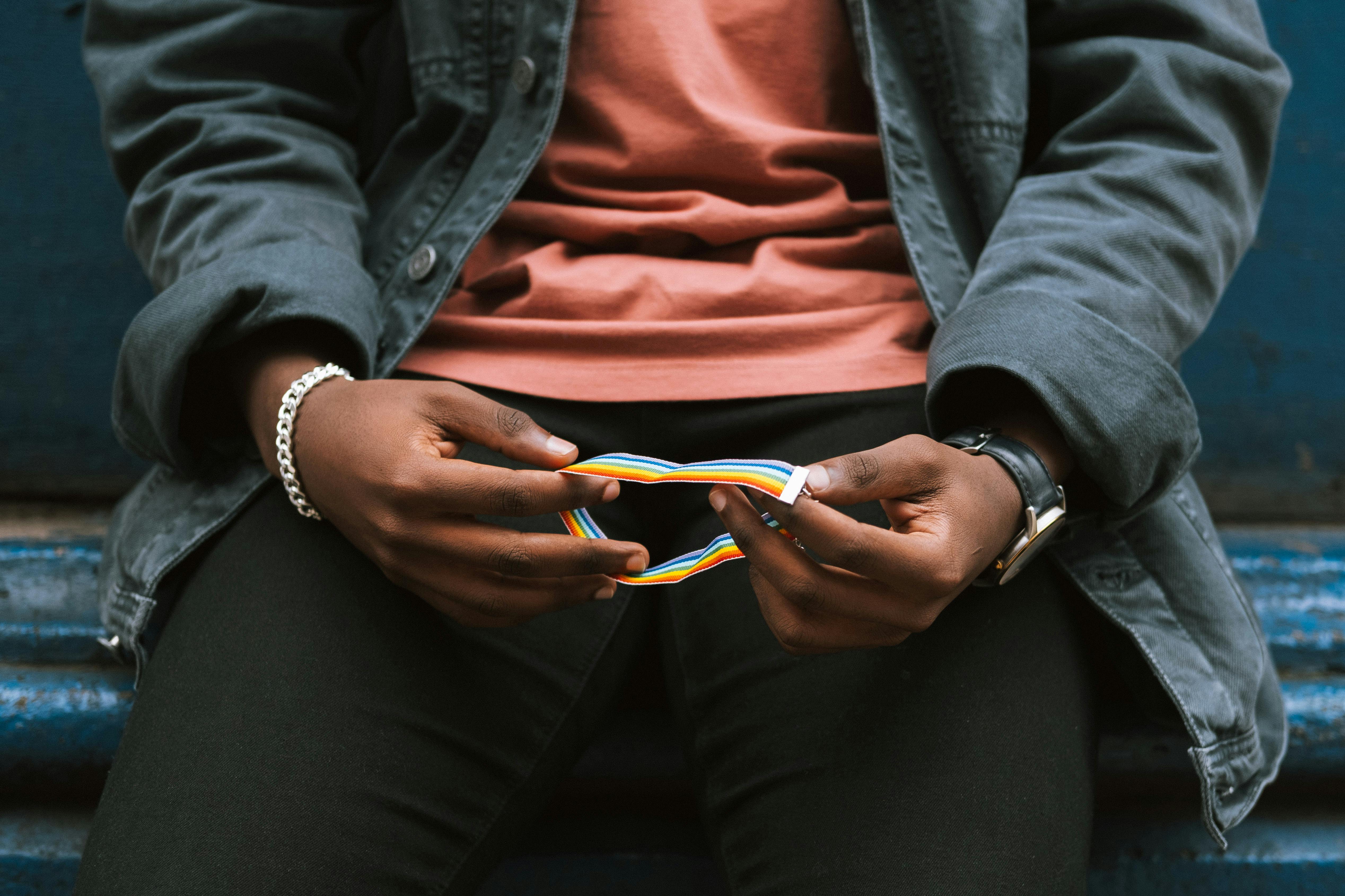 crop unrecognizable black man holding rainbow bracelet