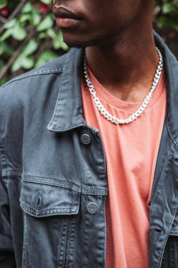 Crop Emotionless Black Man Standing Near Green Fence In Garden