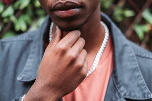 Free Crop black man touching chin thoughtfully in garden Stock Photo