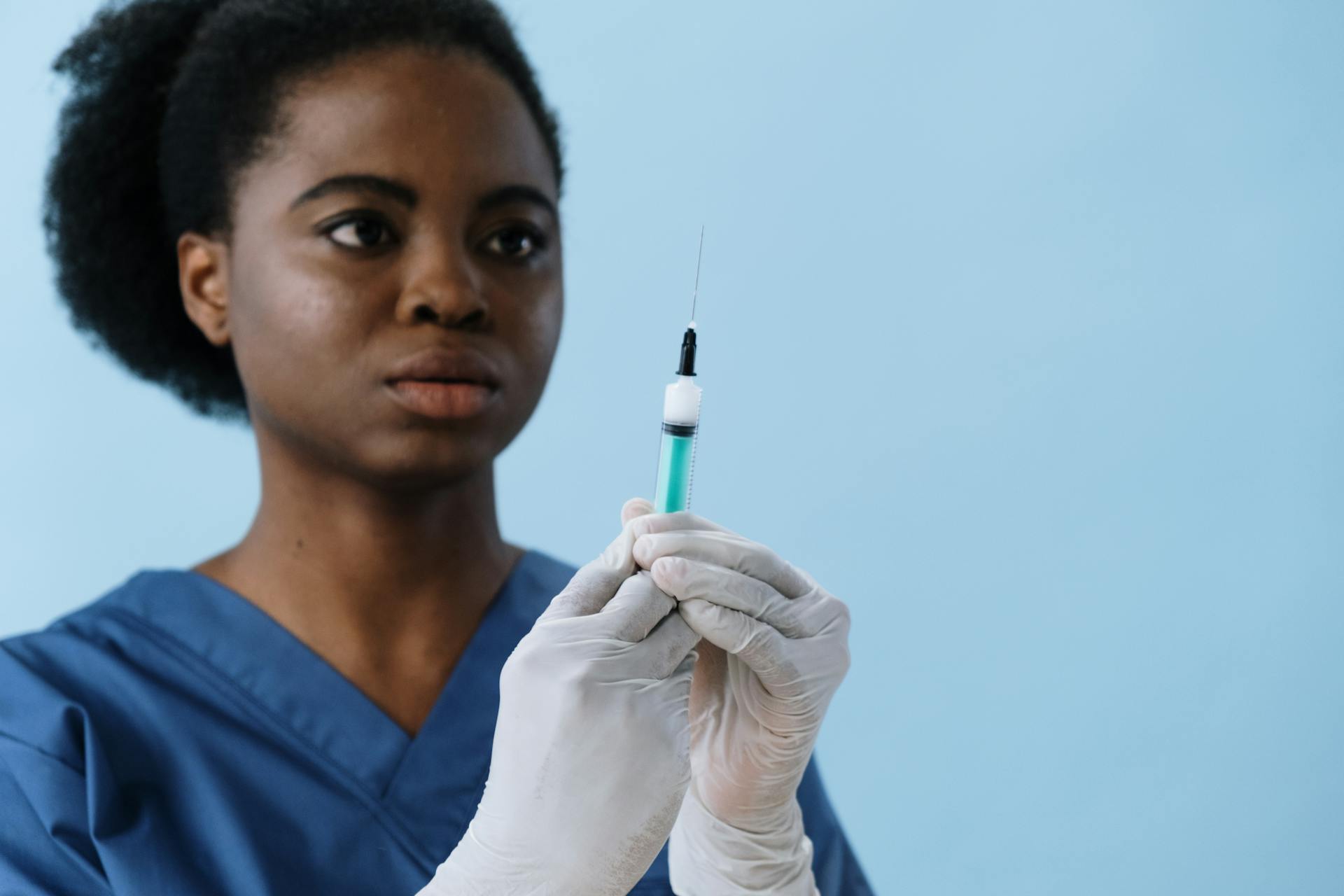 Close-Up Shot of a Female Nurse Holding a Syringe