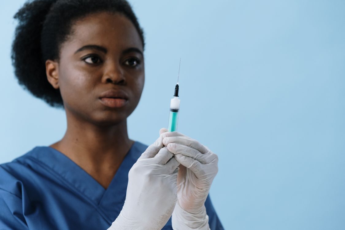 Close-Up Shot of a Female Nurse Holding a Syringe · Free Stock Photo