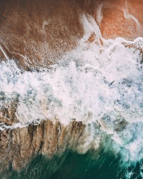 俯瞰碧绿海水，海浪拍打着沙滩