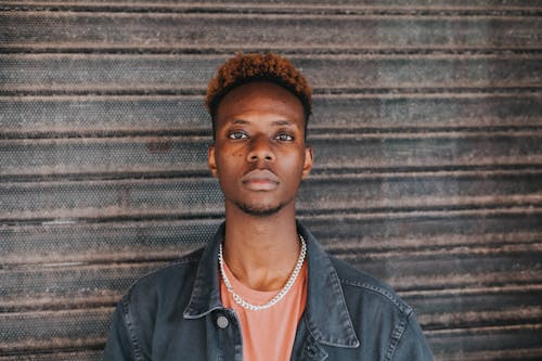 Serious black man standing at wall