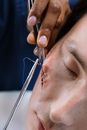 Person Holding Gray Pin on His Face