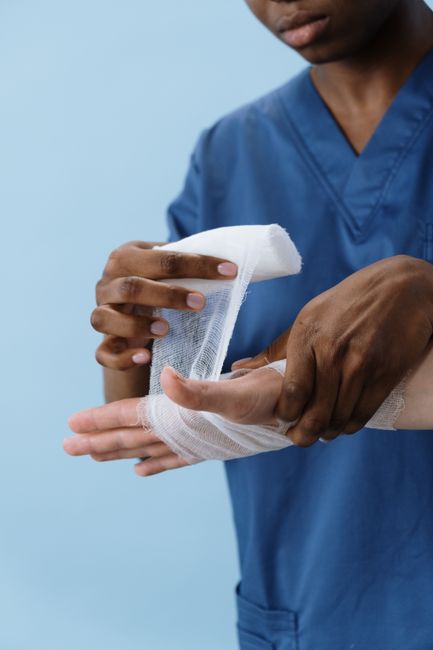 A hand being wrapped with clean gauze after wound care