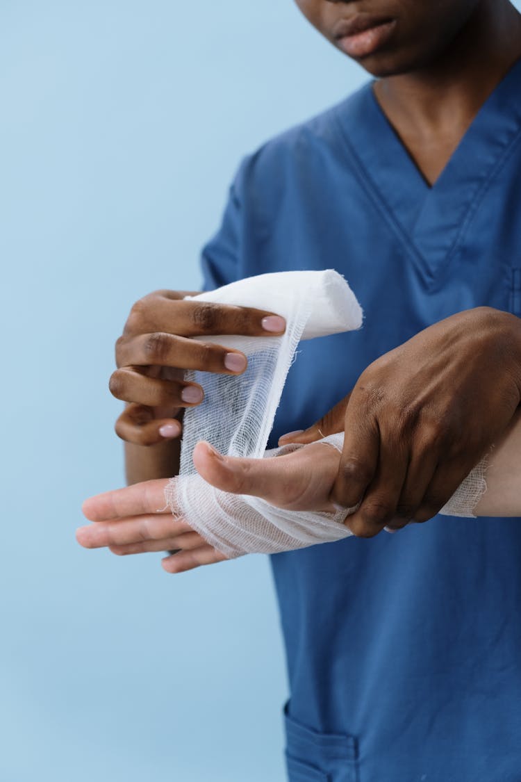 A Person Getting His Hand Bandaged