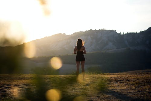 Woman Standing in Mountain Landscape on Sunset