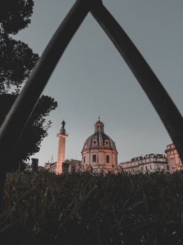 在欧洲老城，一座圆顶天主教大教堂的低角度靠近其高耸的尖顶，尖顶顶部立有雕像