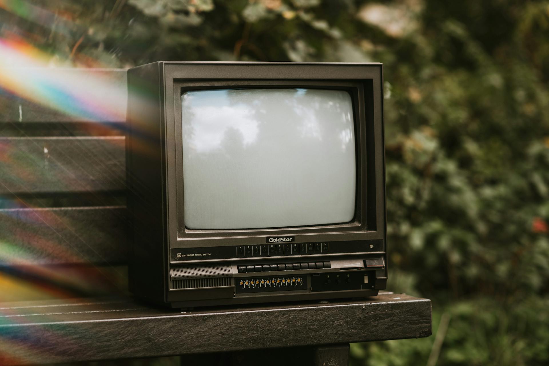 Retro TV set on bench in park