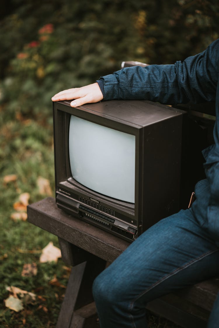 Crop Man With Old TV Set In Park