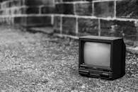 Retro TV set on ground near barrier