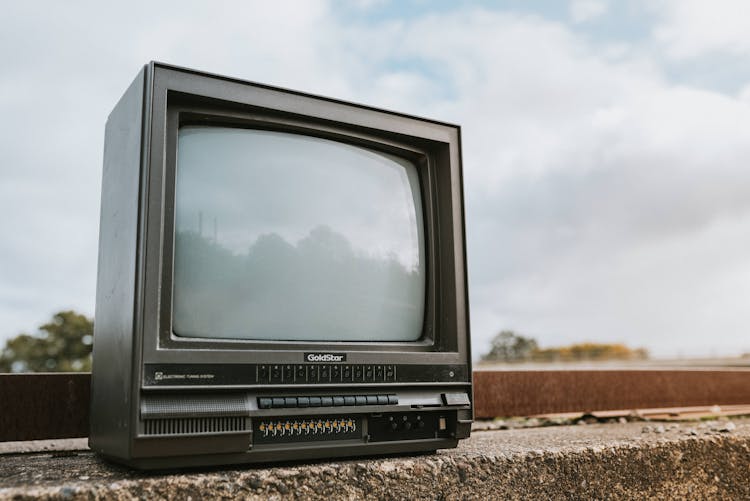 Vintage TV Set Placed On Stone Barrier