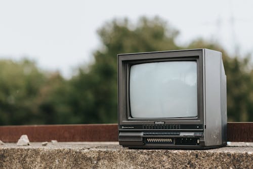 棕色混凝土表面上的黑色crt電視