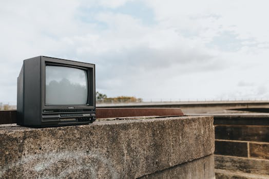 Aged CRT television placed on weathered concrete outdoors, evokes nostalgia.