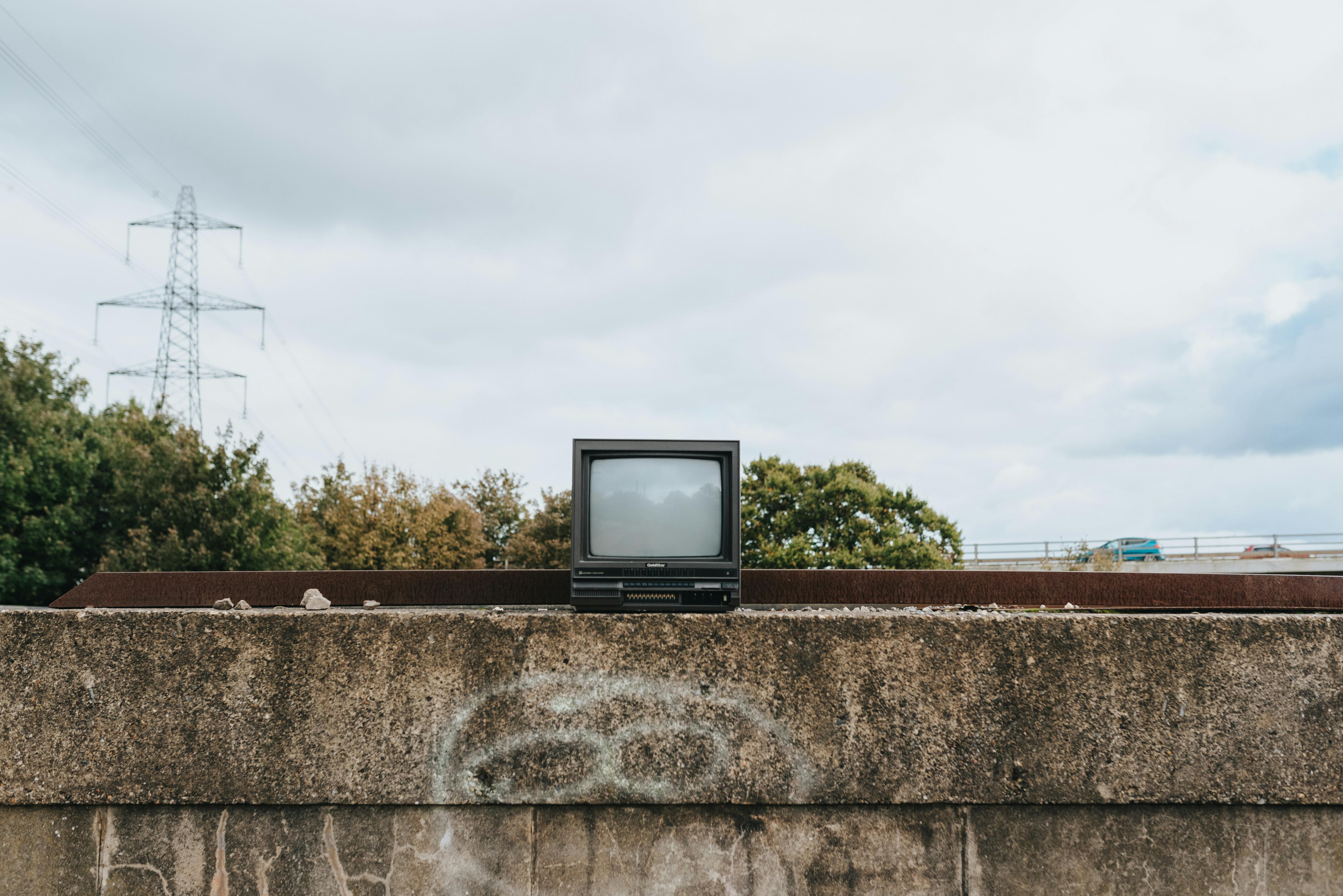 small vintage tv set on stone fence