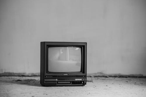 無料 白い壁に黒いブラウン管テレビ 写真素材