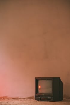 An old CRT TV in a minimalist room with warm lighting and vintage style.