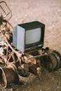 Vintage television set on rusty vehicle on pathway