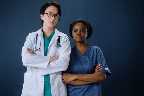 Free A confident doctor and nurse posing in a studio setting. Stock Photo