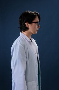一位成年男医生的侧面轮廓，他穿着白外套，背景是深色的