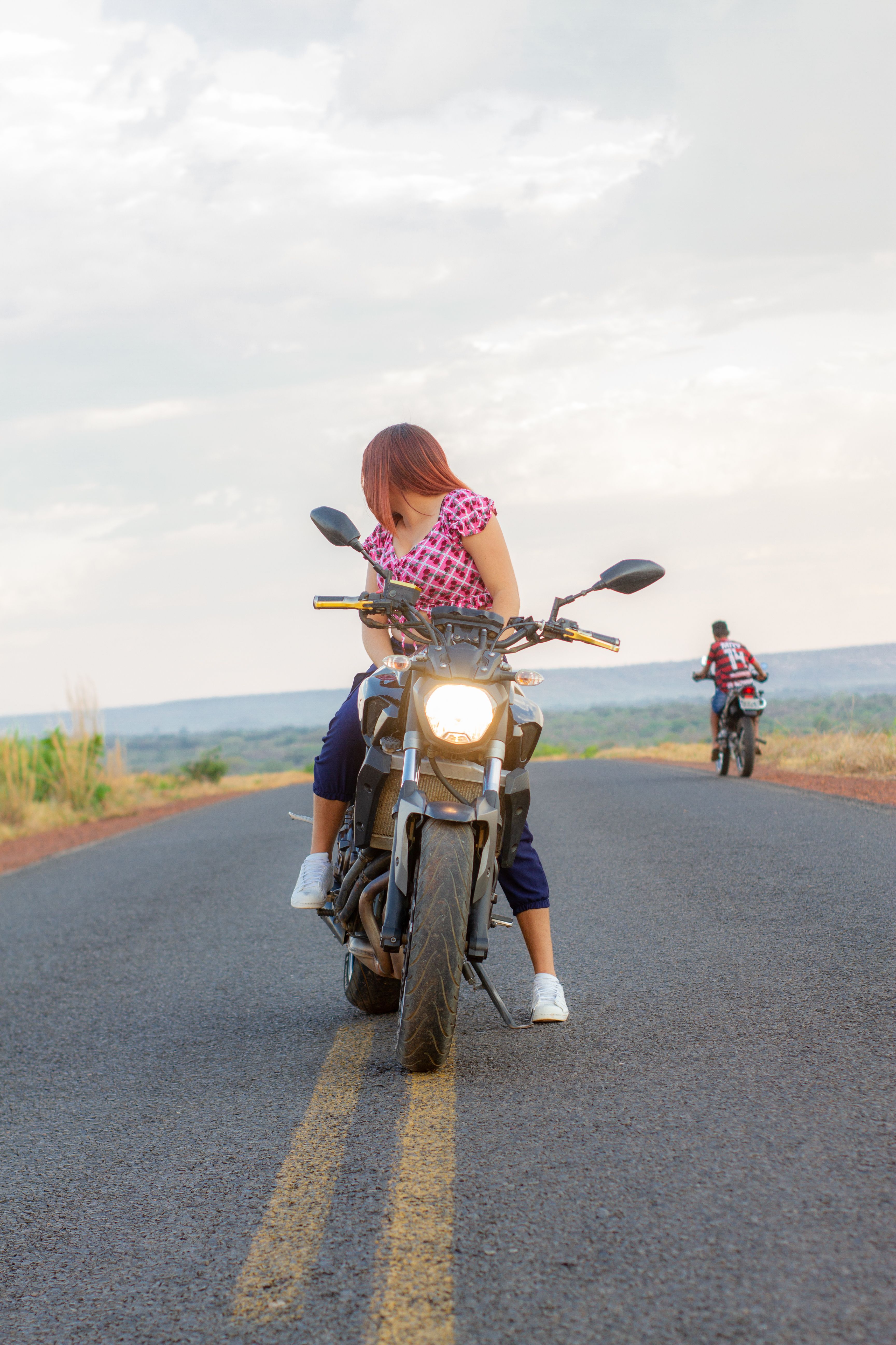 Woman in Pink Shirt Riding a Motorcycle on Road · Free Stock Photo