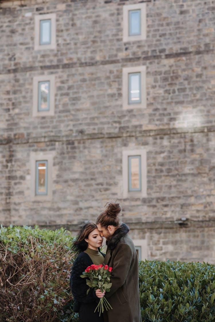 Couple With Rose Bouquet Embracing In City