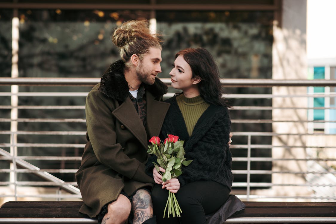 Free Hipster man with girlfriend and flowers on street bench Stock Photo