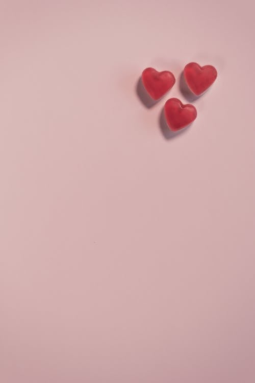 Конфеты в форме красного сердца на белой поверхности