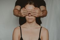 Crop man covering eyes of anonymous woman
