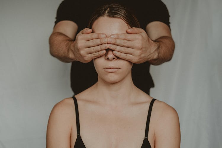 Crop Man Covering Eyes Of Anonymous Woman