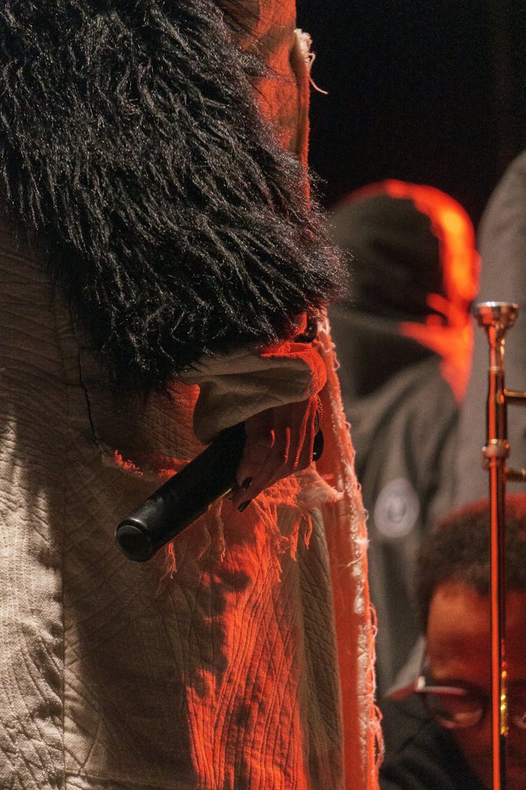 Crop Woman Standing With Microphone On Stage