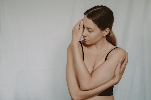 Woman in underwear touching face in studio