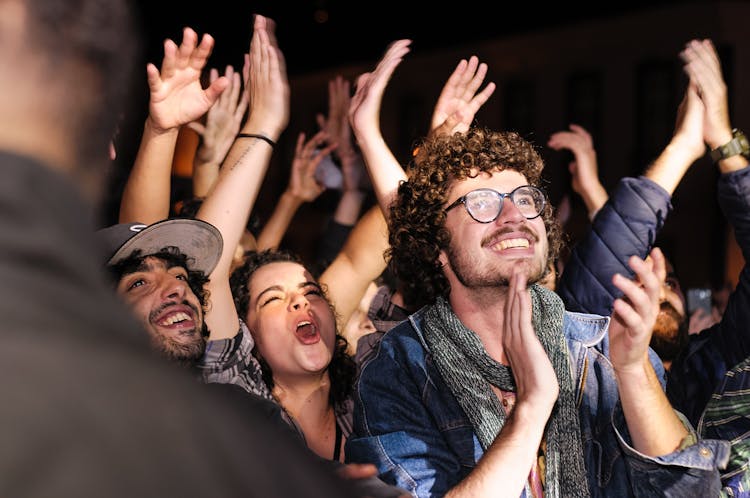 Joyful Audience Raising And Clapping Hands At Party