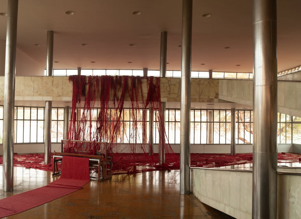 Free Interior of spacious hall with weaving loom and messy thread hanging on balcony Stock Photo